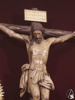 El crucificado está inspirado en el Cristo del Amor de Sevilla y representa a Jesús muerto en la Cruz. No suele procesionar ni con corona de espinas ni con potencias, pero en casos especiales ambas les son colocadas