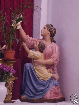 Una mujer con un niño, imágenes también de serie, presencian la entrada de Jesús en Jerusalen 