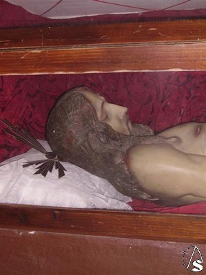 A los pies de la Virgen, en la base del altar se abre una urna donde se encuentra la imagen del Cristo Yacente 